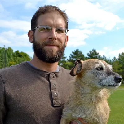 Tyler Muto holding a small terrier mix