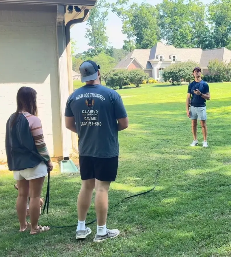 Bailey Clark coaching a couple on long-line recall in their backyard during a private lesson